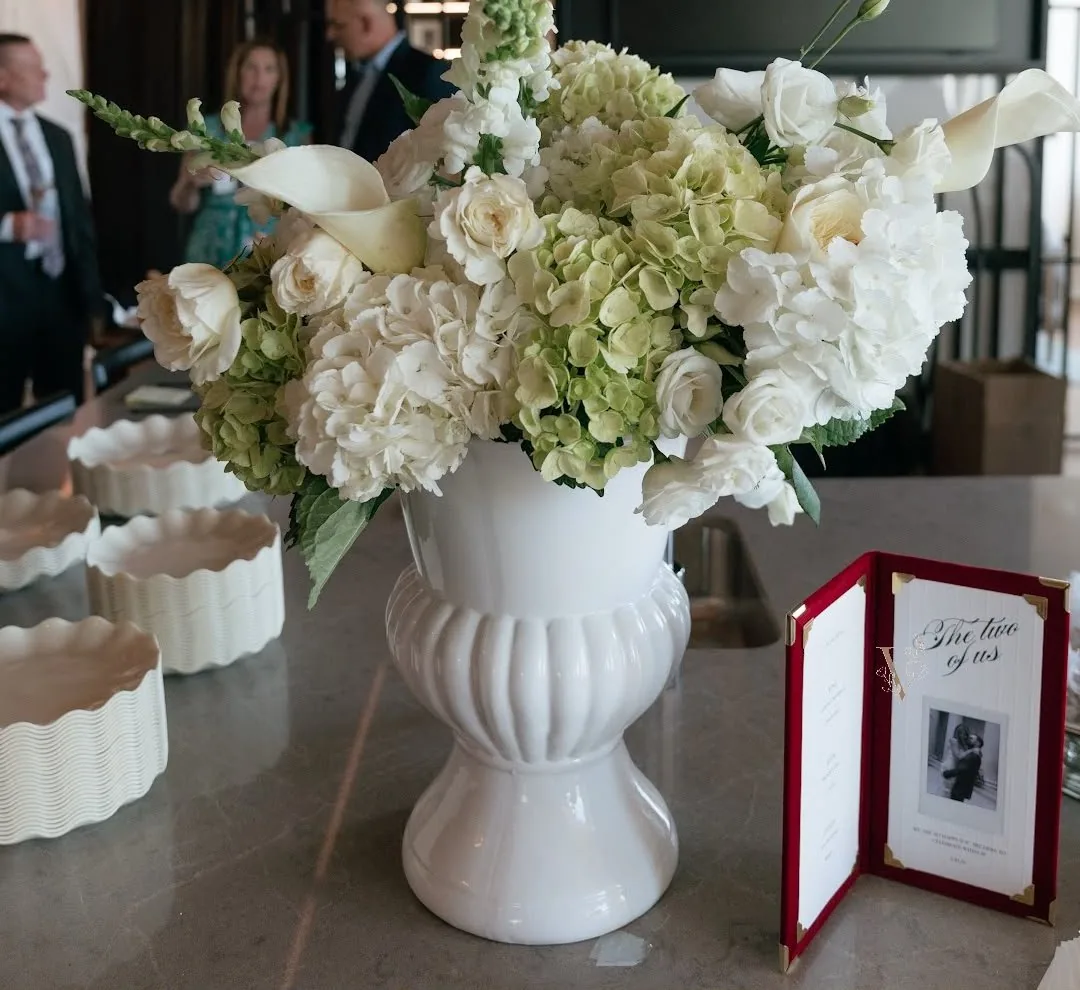 White urn arrangement styled on site at a client engagement party